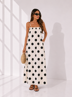 Woman wearing a polka dot dress in a minimal white room