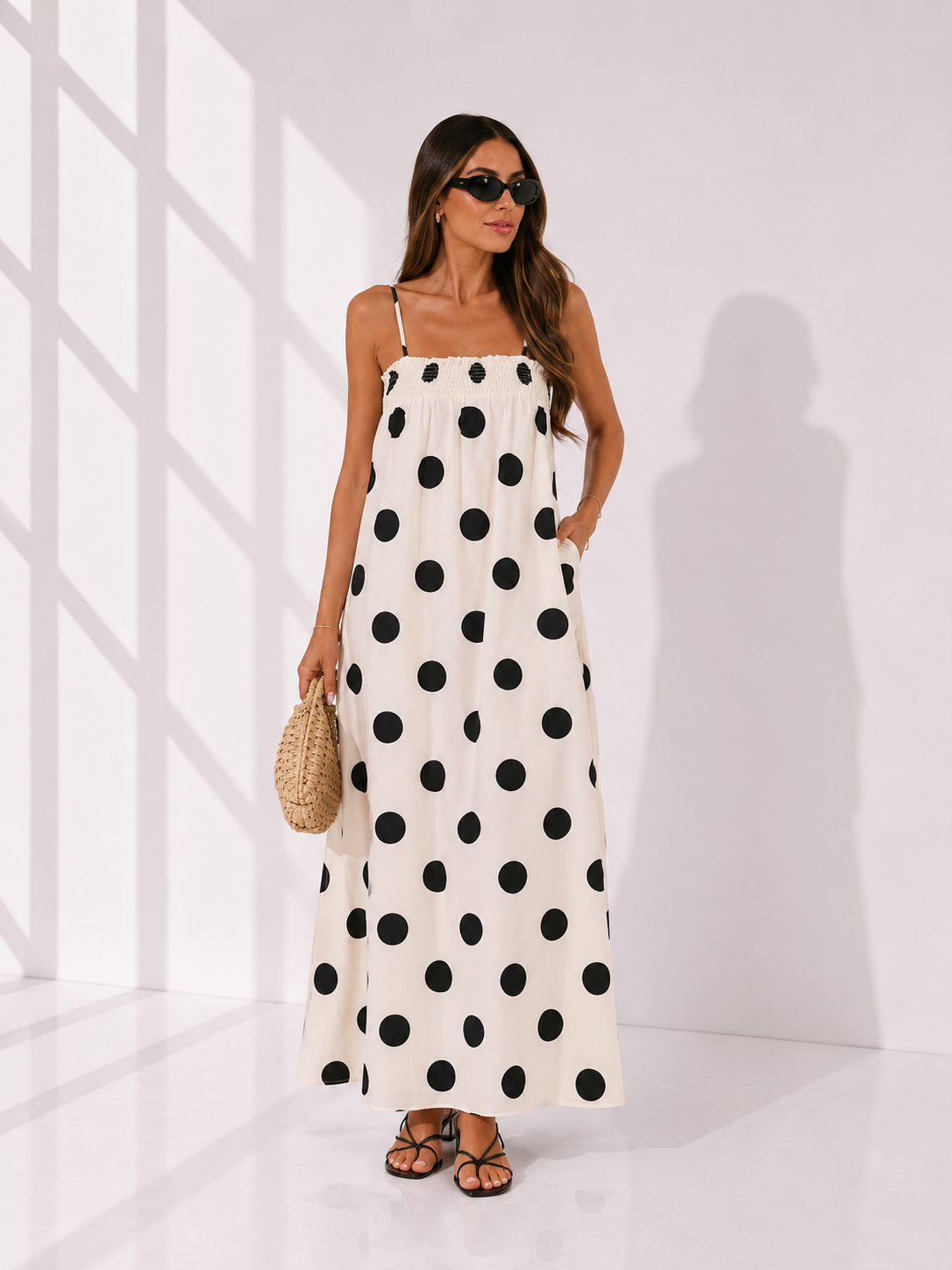 Woman wearing a polka dot dress in a minimal white room