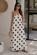 Woman wearing a polka dot dress standing outdoors.
