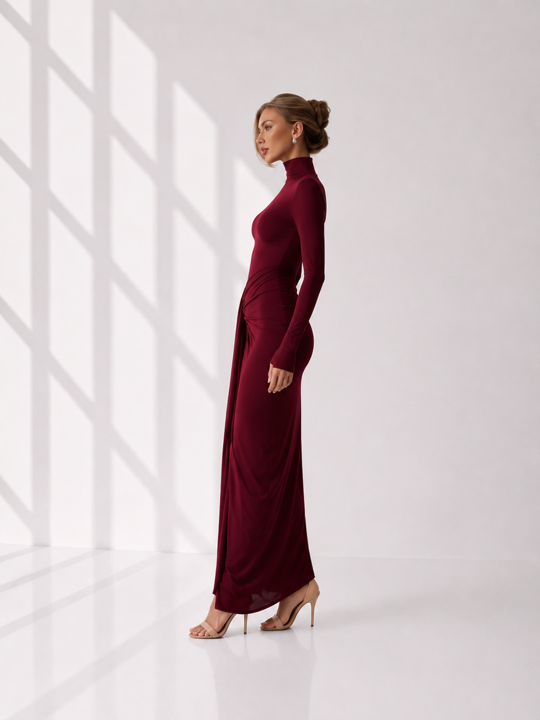 Woman wearing a burgundy dress with long sleeves and a high neckline.
