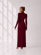 Woman wearing a burgundy long-sleeve dress against a white background
