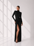 Woman wearing a black dress with a high slit in a minimalistic setting
