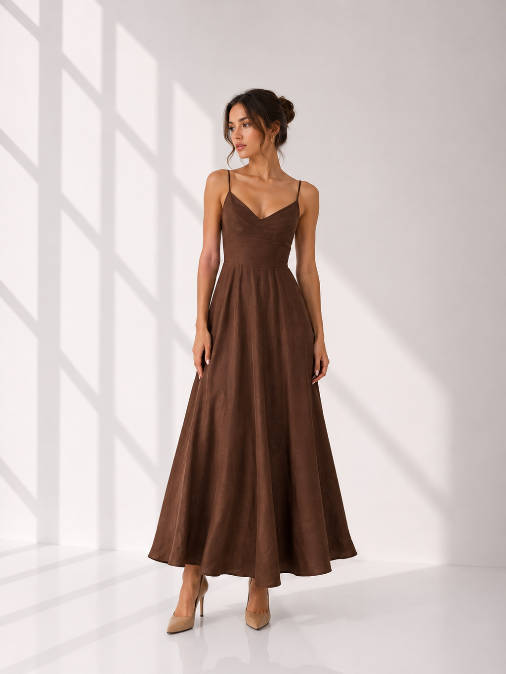Woman wearing a brown dress standing against a white background