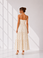 Woman wearing a polka dot dress in a bright room with sunlight filtering through.
