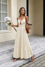 Woman wearing a polka dot dress holding flowers and two coffee  cups 