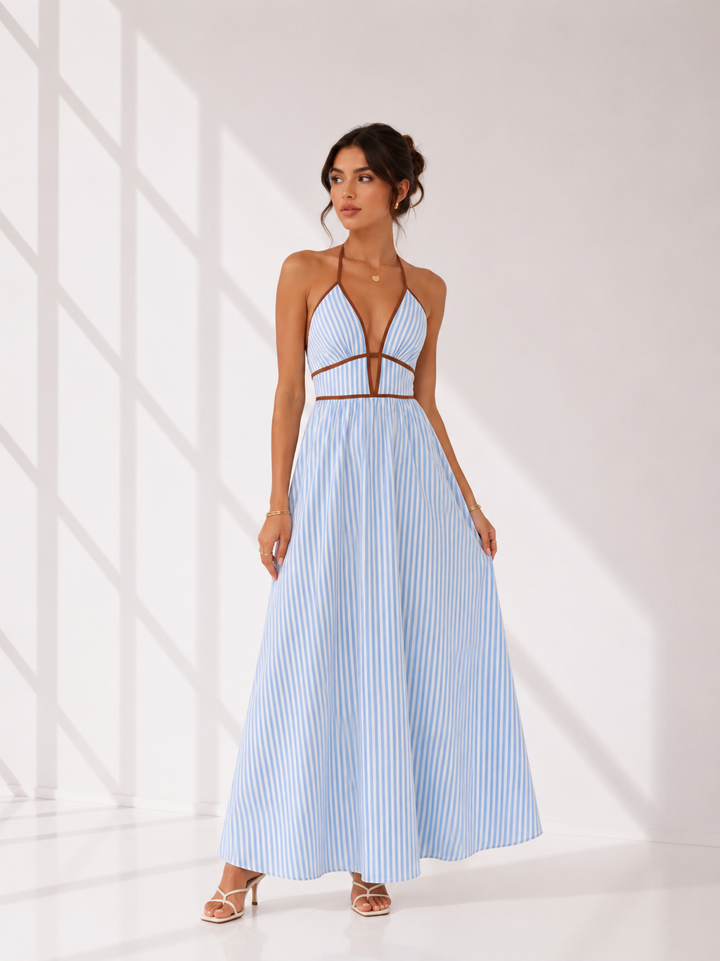 Woman wearing a light blue striped dress with cut-out design on a white background