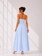 Woman wearing a light blue strapless dress with vertical stripes against a white background