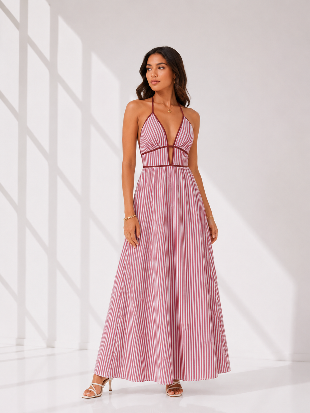 Woman wearing a pink and white striped dress against a white background