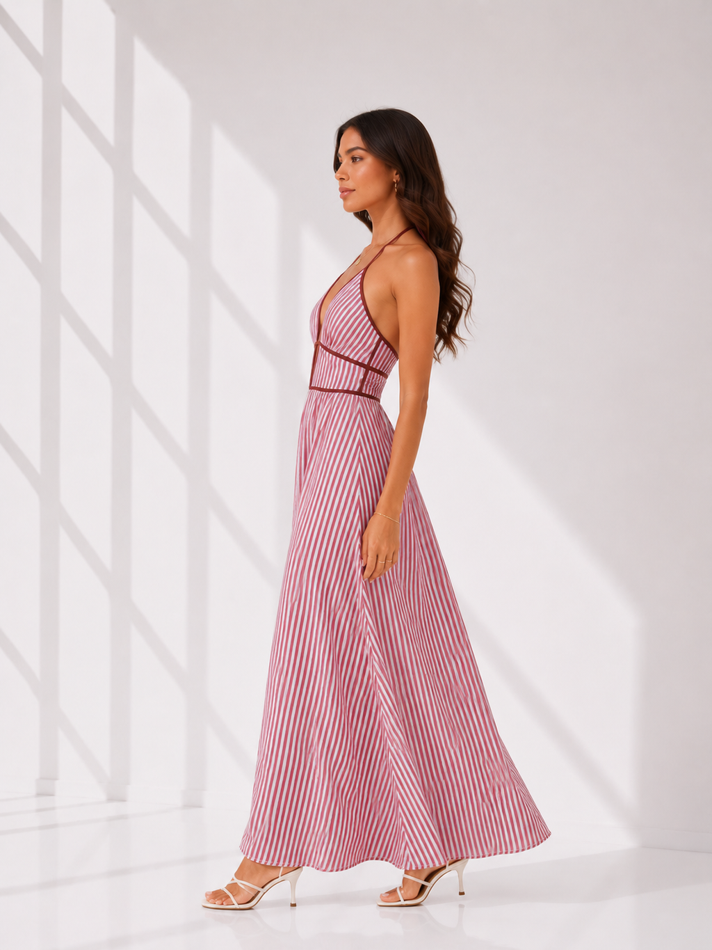 Woman wearing a pink and white striped dress against a white background