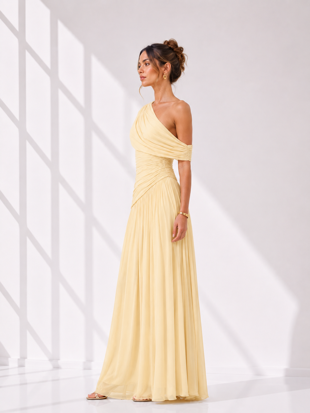 Woman wearing a yellow one-shoulder dress against a white background