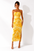 Woman wearing a yellow tie-dye strapless dress on a white background