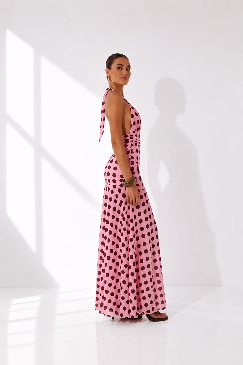 Woman wearing a pink polka dot dress on a white background