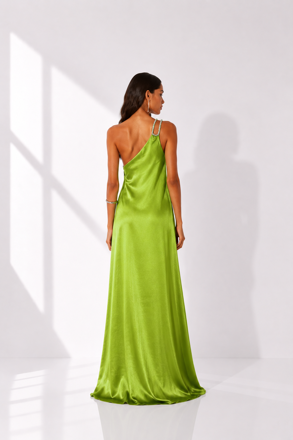 Woman wearing a green satin dress against a white background