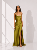 Woman wearing a green evening gown with a high slit in a minimalistic setting