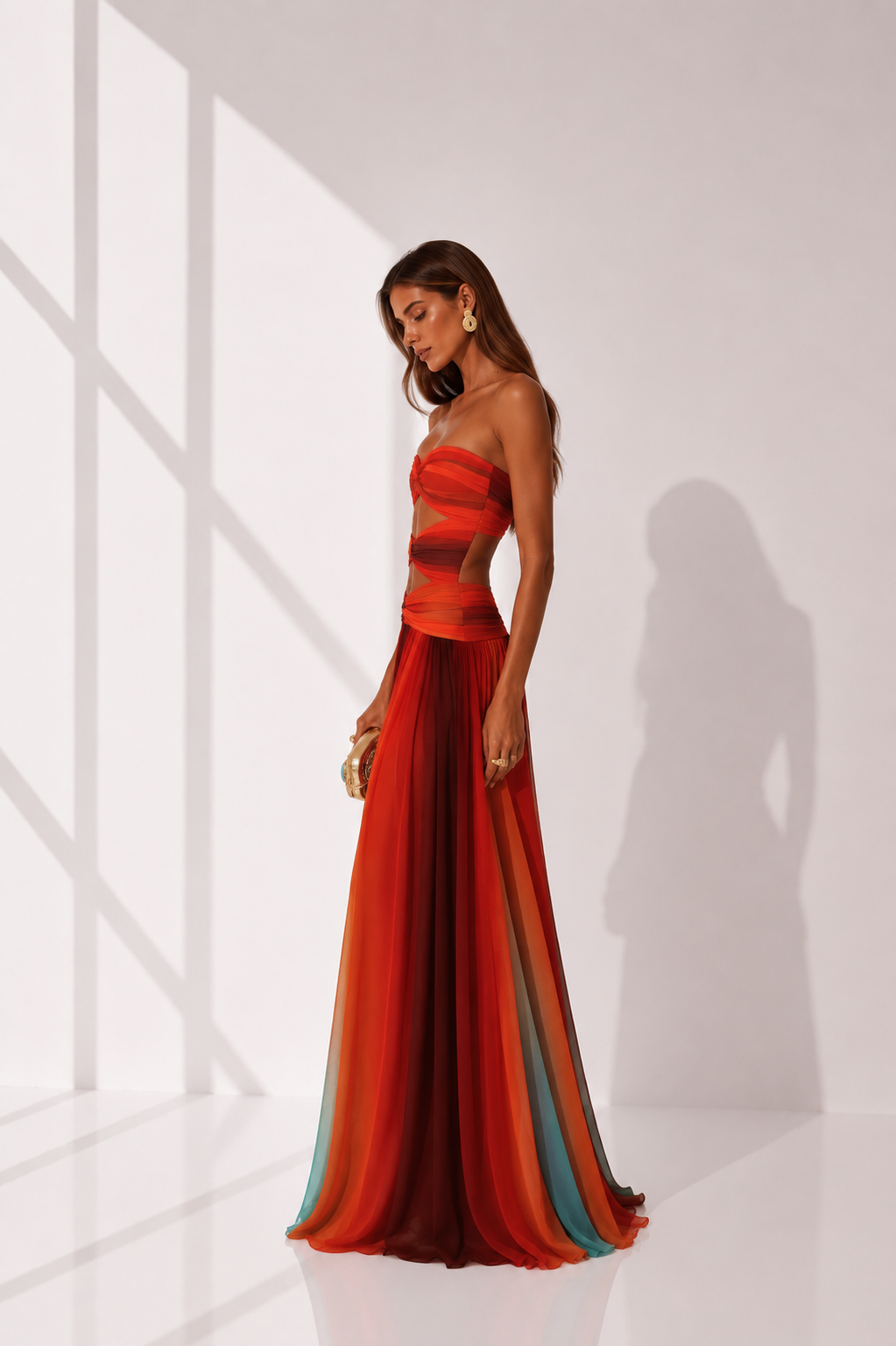 Woman wearing a strapless, long, multicolored dress against a white background