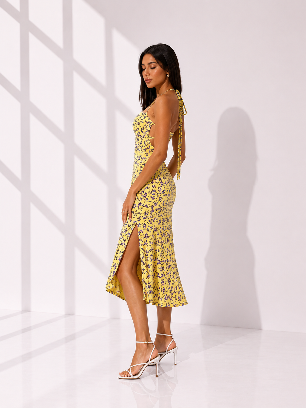 Woman wearing a yellow floral dress in a bright room