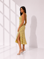 Woman wearing a yellow floral dress in a bright room