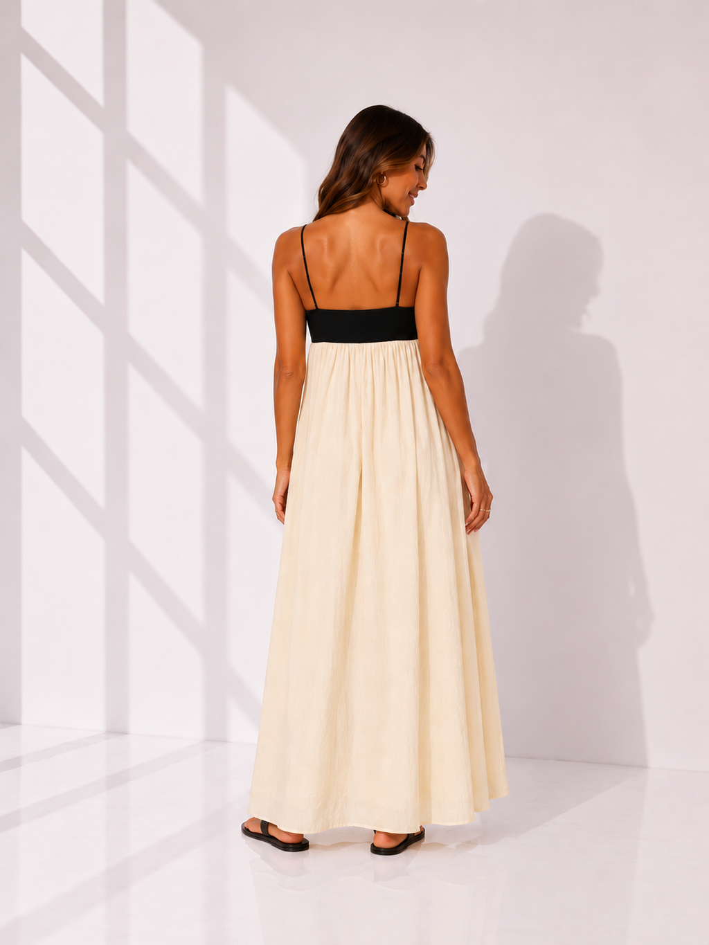 Woman wearing a black and white dress against a white background