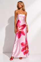 Woman wearing a pink strapless dress with floral patterns on a white background