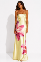 Woman wearing a strapless yellow dress with pink floral patterns on a white background