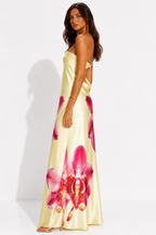 Woman wearing a yellow dress with pink floral patterns on a white background