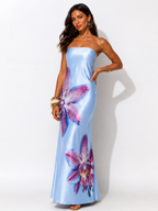 Woman wearing a blue strapless dress with floral patterns on a white background