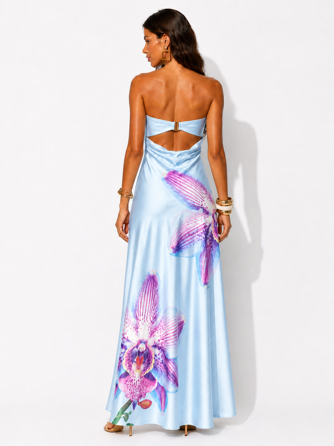 Woman wearing a light blue dress with floral designs on a white background