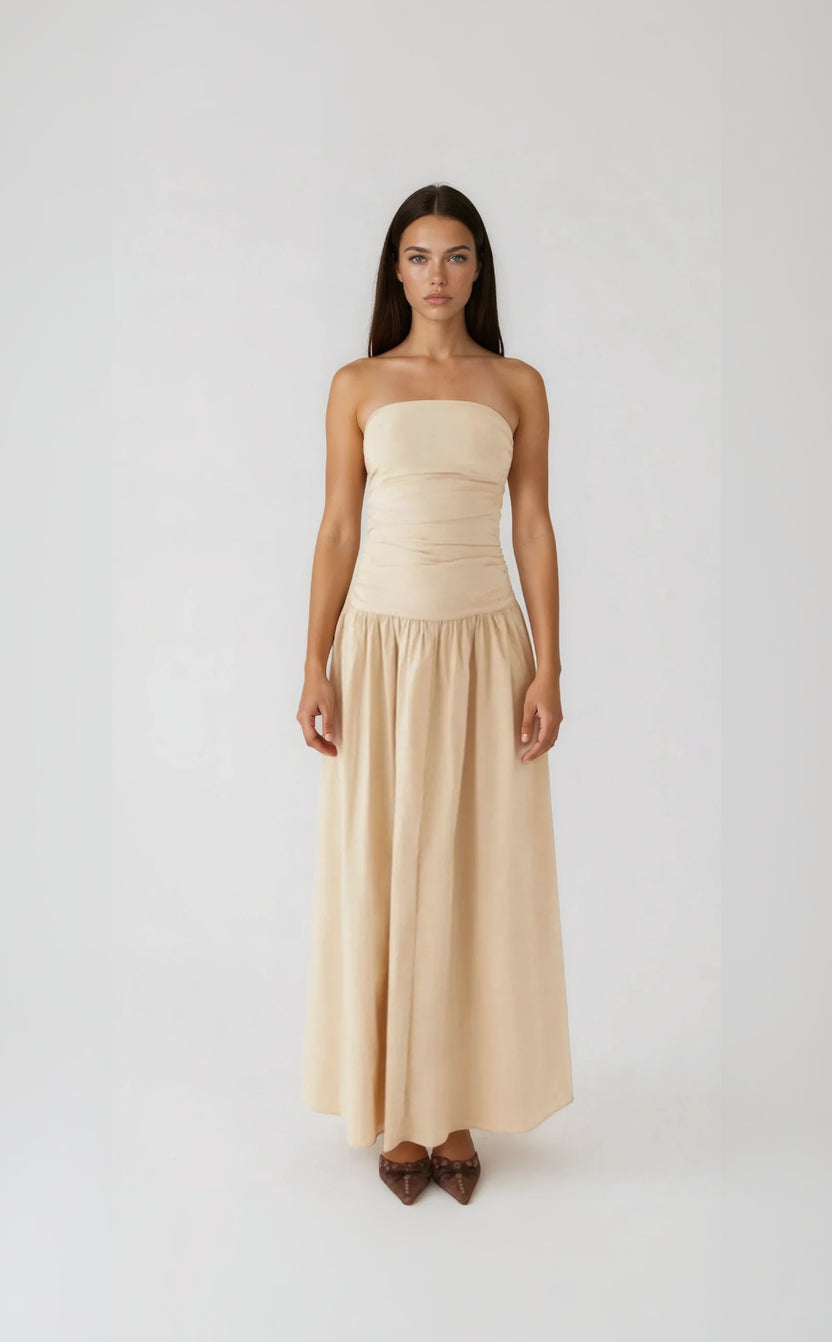 Woman wearing a strapless beige dress against a white background