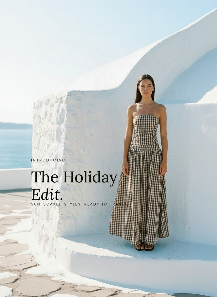 Woman in a checkered dress standing in front of white stone architecture with text 'The Holiday Edit' on a blue background.