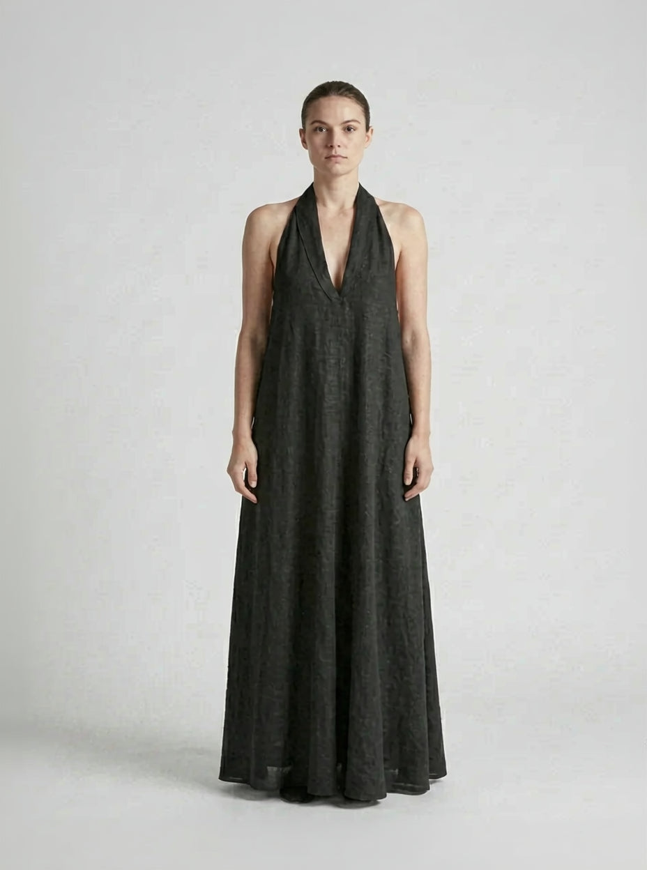 Woman wearing a black halter neck dress on a white background