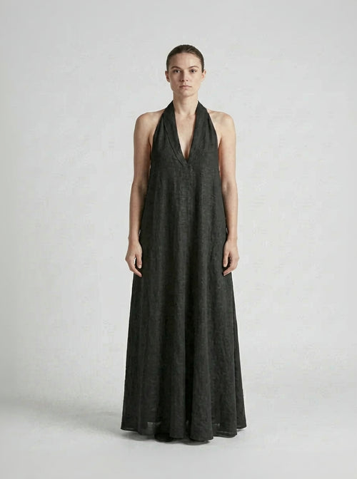 Woman wearing a black halter neck dress on a white background