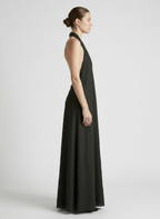 Woman wearing a black halter neck dress on a white background