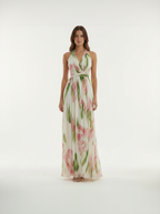 Woman wearing a floral maxi dress on a white background