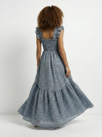 Woman wearing a blue checkered dress with a white background
