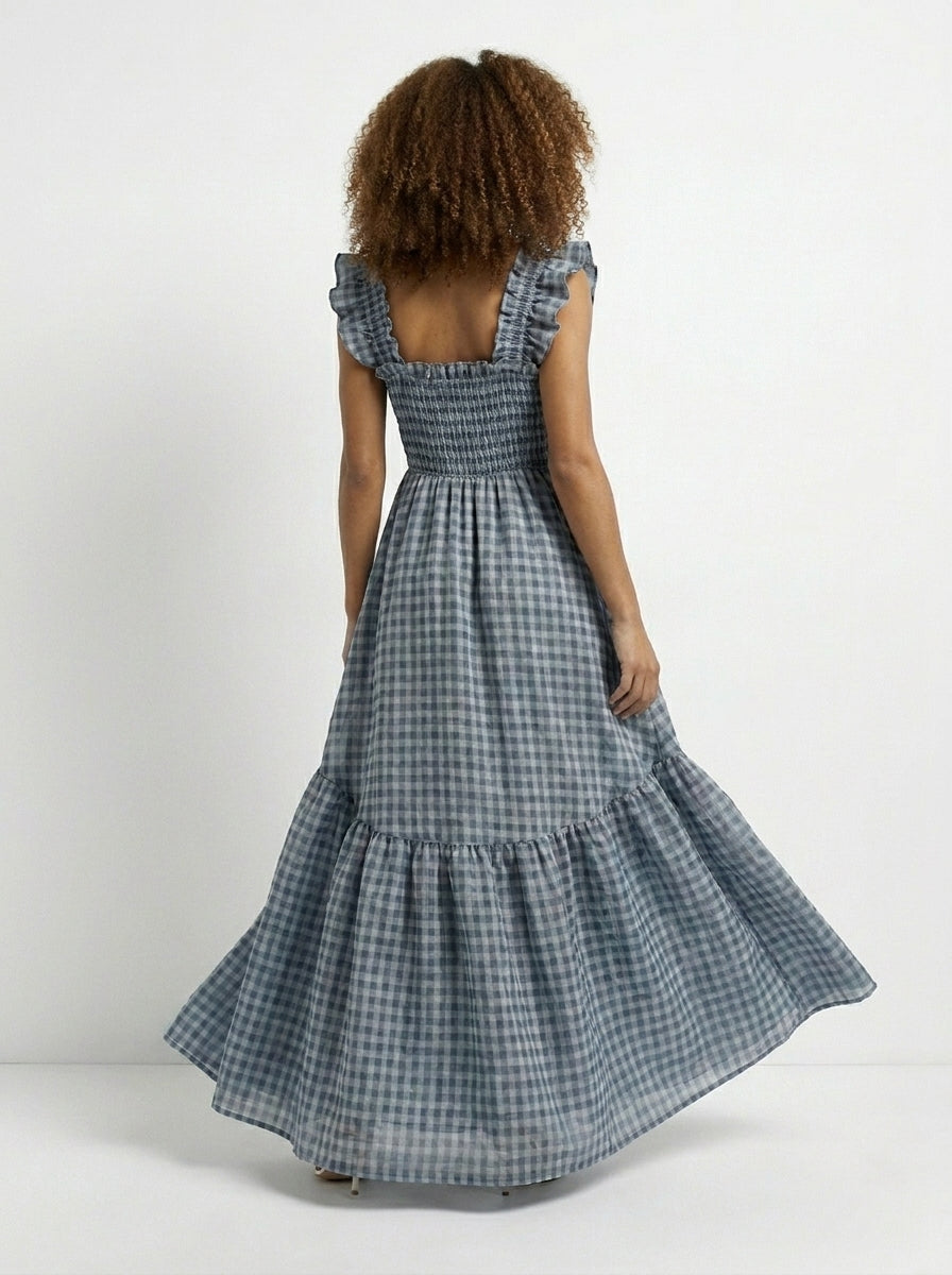 Woman wearing a blue checkered dress with a white background