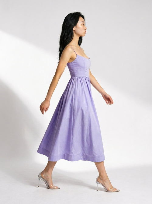 Woman wearing a light purple strapless dress on a white background