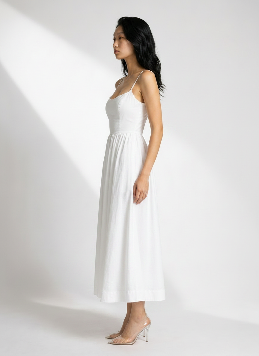 Woman wearing a white dress against a white background