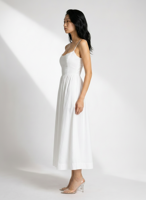 Woman wearing a white dress against a white background