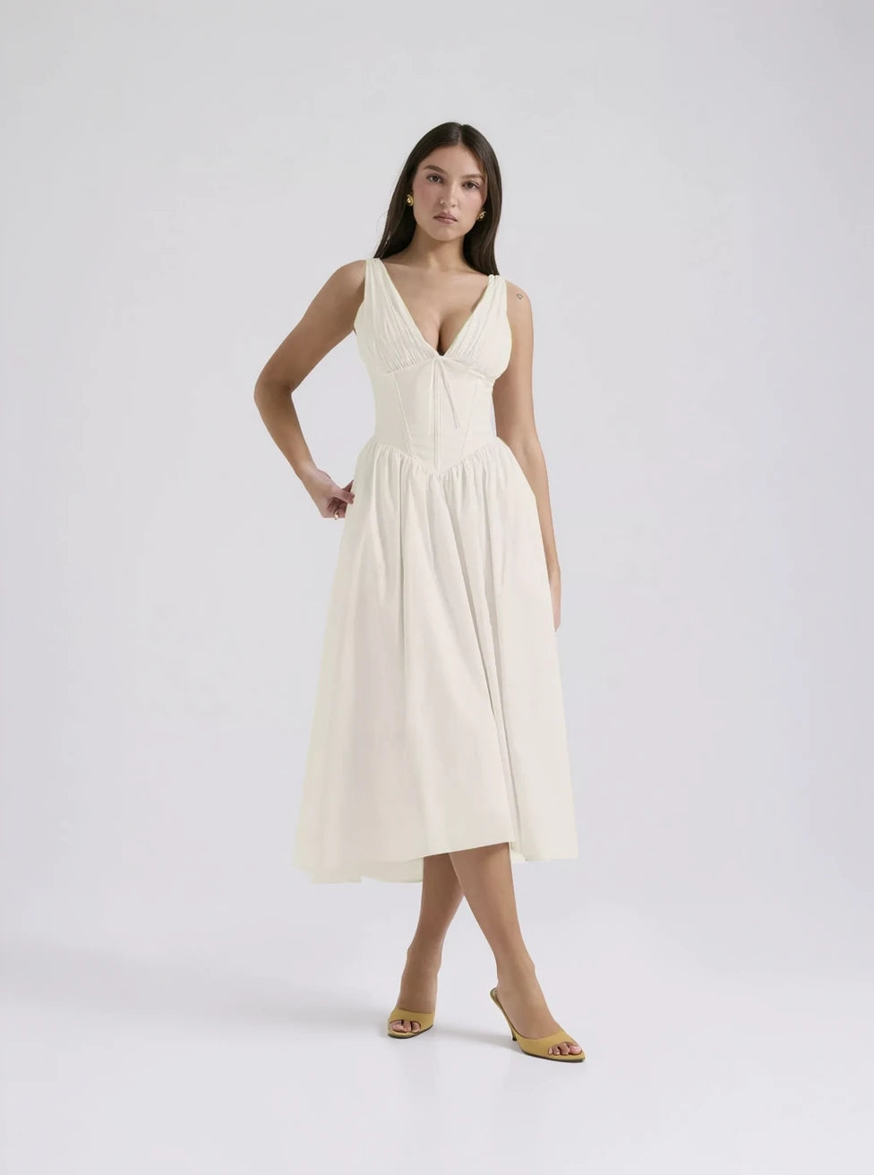 Woman wearing a white dress on a plain background