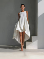 White dress worn by a model against a gray background