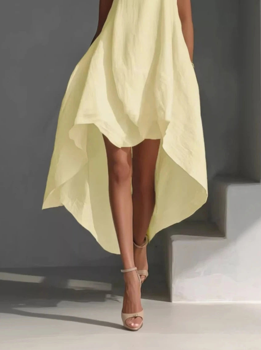 Person wearing a light yellow dress with a dark background
